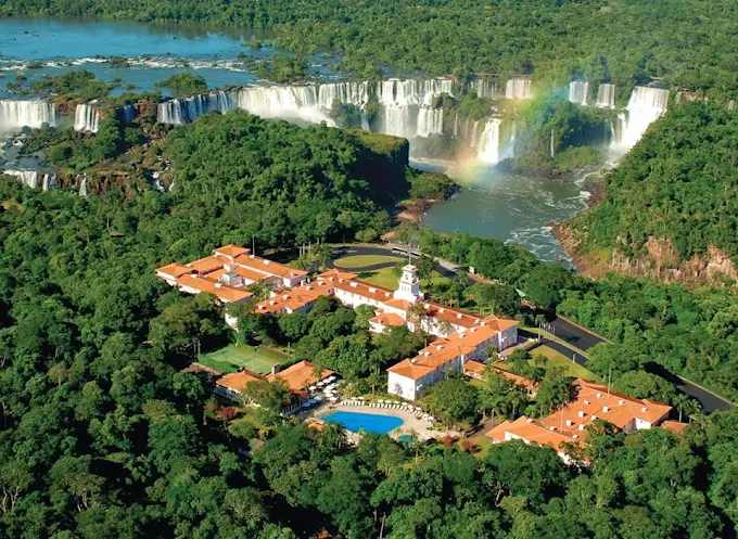 a building surrounded by trees and a waterfall