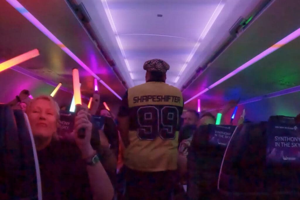 a man in a yellow shirt holding a light saber