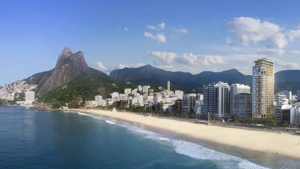a beach with buildings and mountains in the background