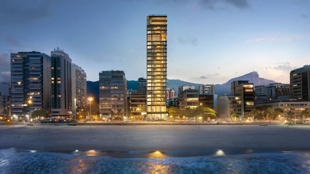 a tall building with lights on the side of a beach