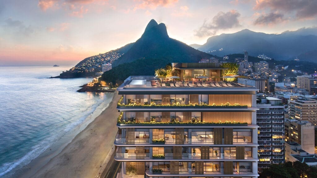 a building with a beach and mountains in the background