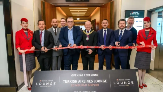 a group of people in suits cutting a red ribbon