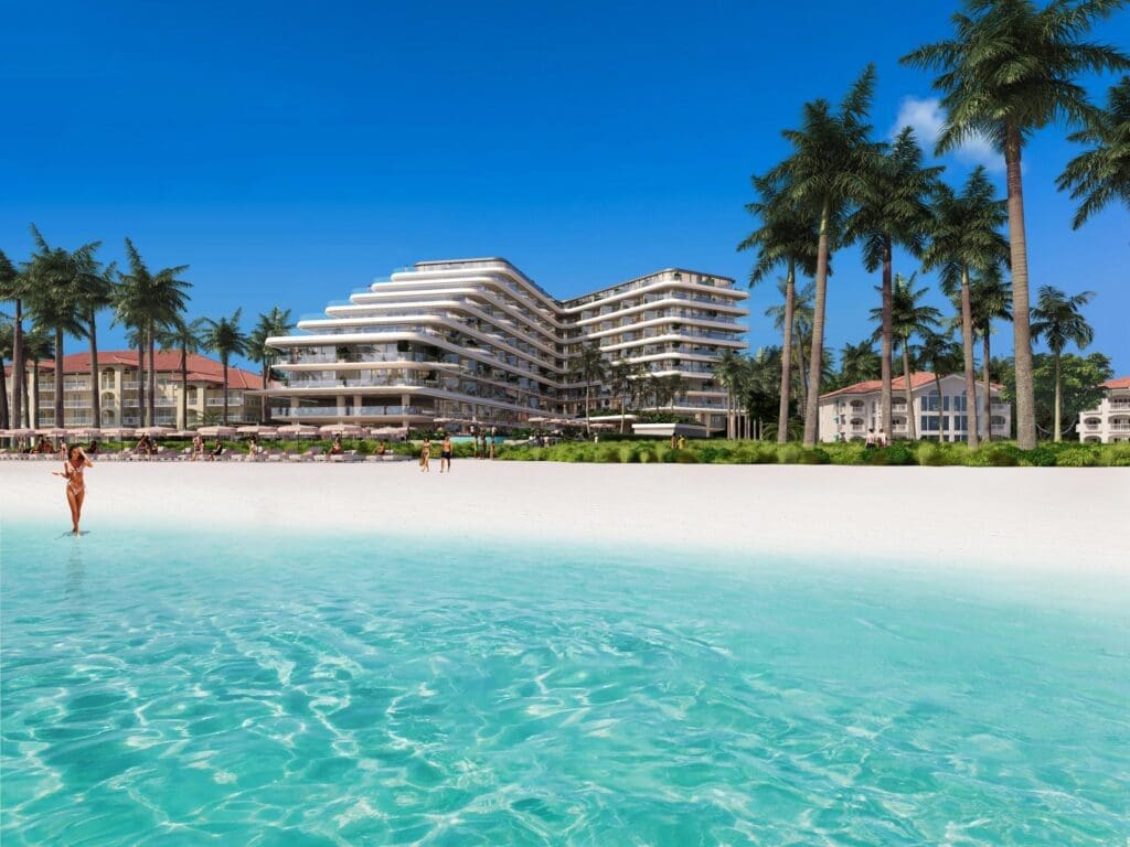 a beach with a large building and palm trees