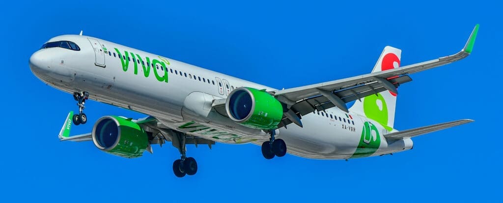 a white and green airplane in the sky