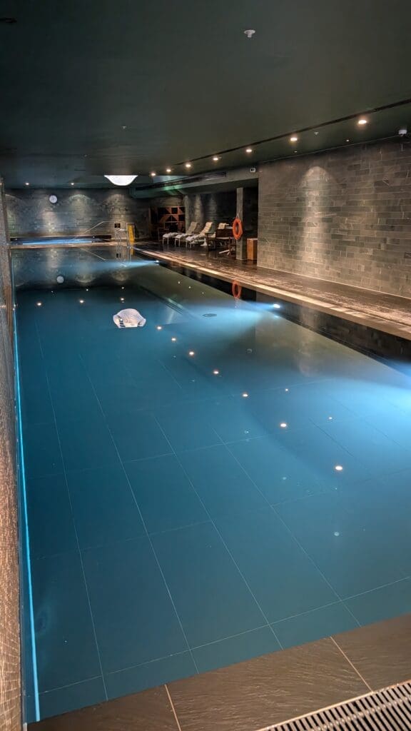 a swimming pool with a stone wall and a brick wall