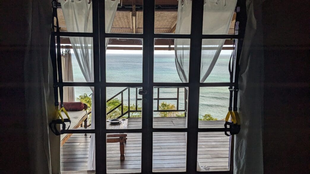 a glass door with a view of the ocean