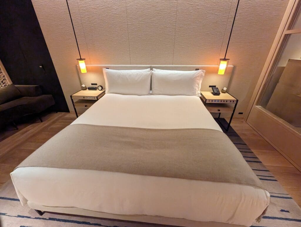 a bed with two lamps above it