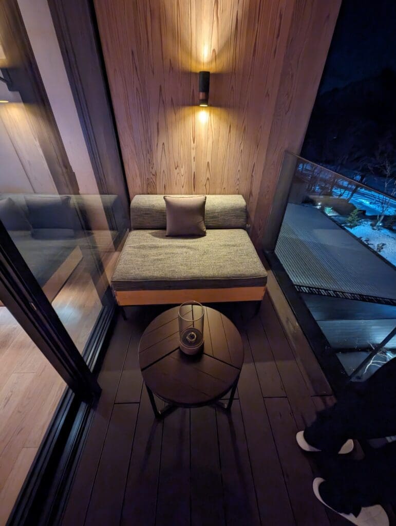 a small table and a couch in a room with glass walls