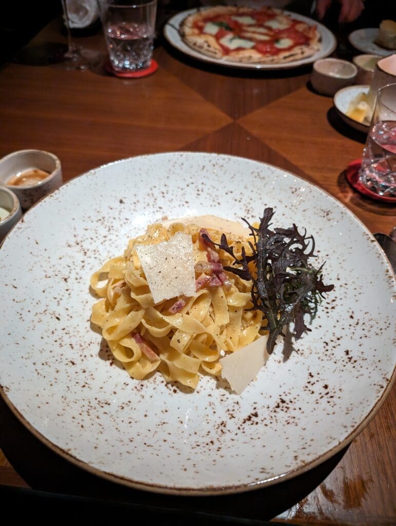 a plate of pasta with sauce and other dishes on a table
