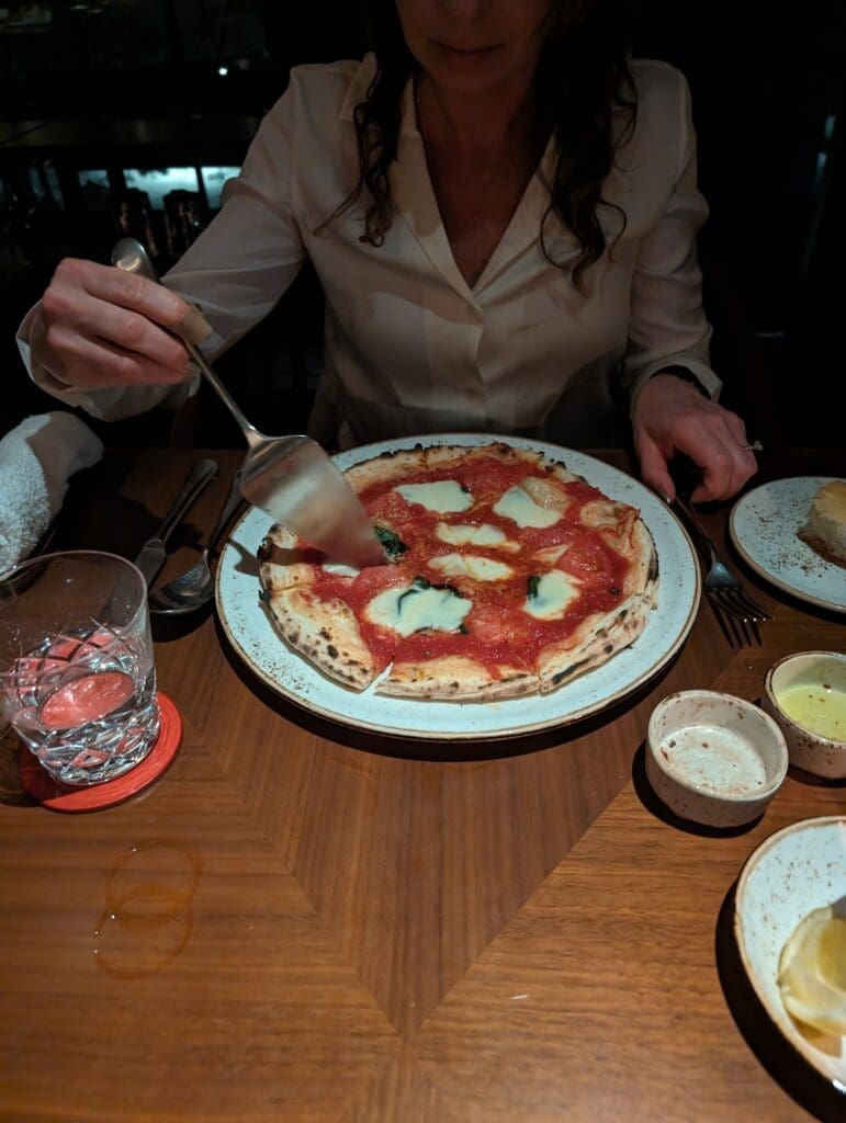 a person cutting a pizza