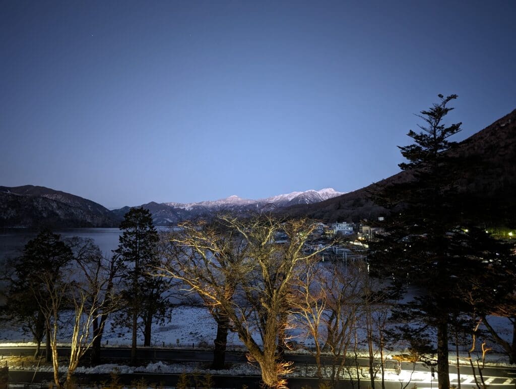 a lake with trees and mountains in the background
