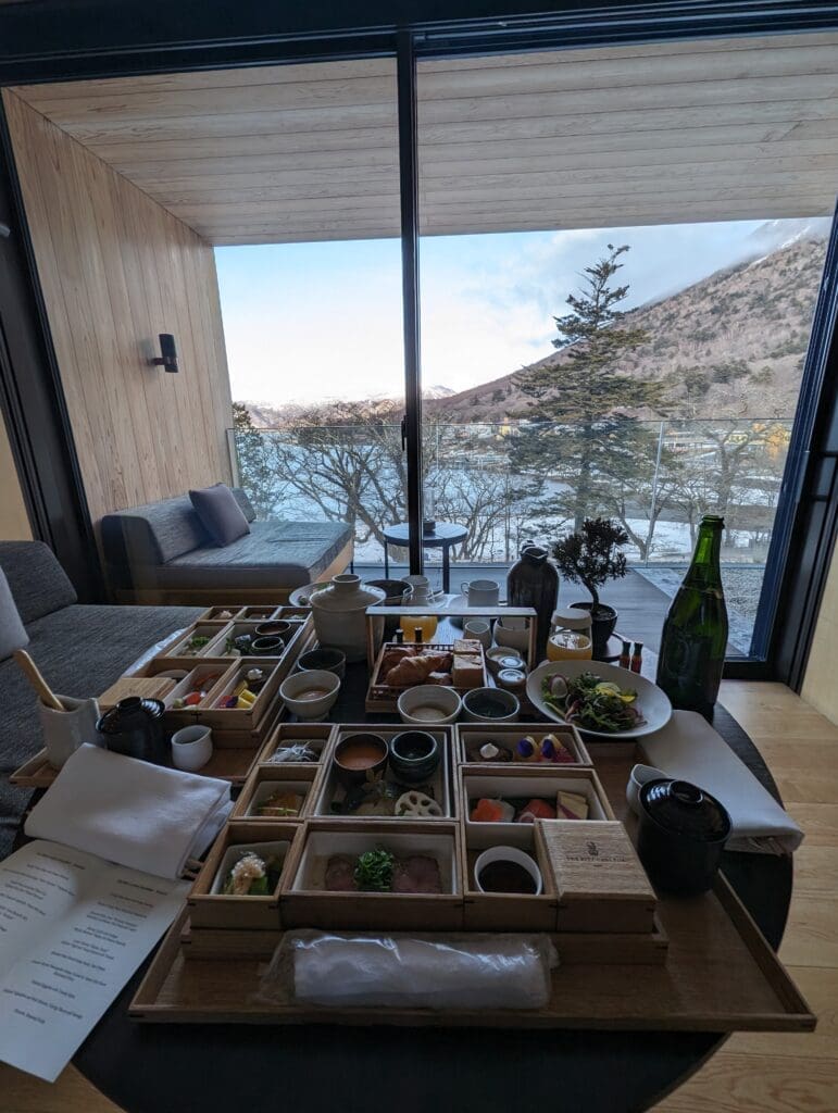 a table with food on it and a couch and a glass door