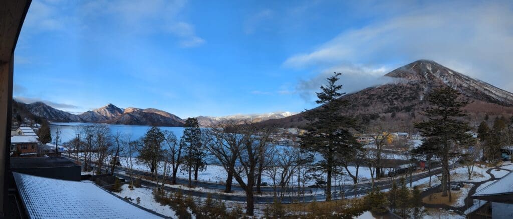 a road with trees and a lake in the background