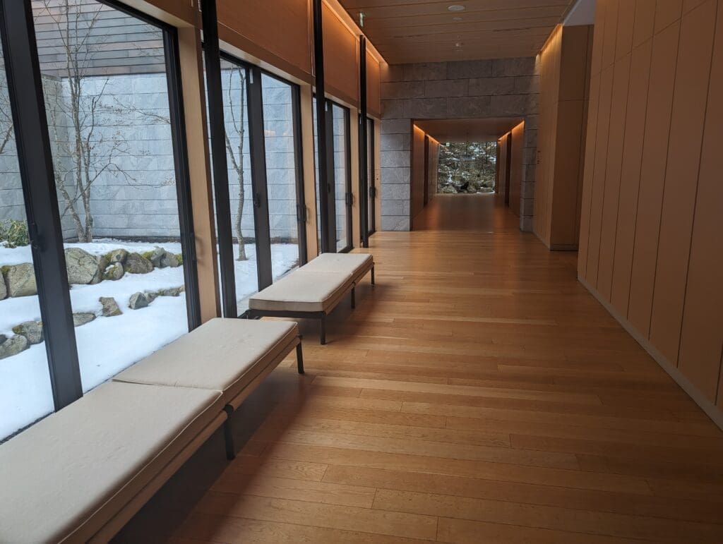 a long hallway with benches and a large window