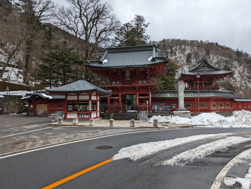 a building with a red roof and a couple of buildings with snow