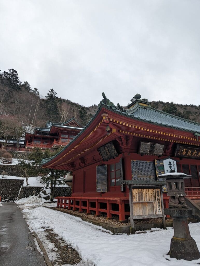 a building with a red roof and a snowy hill
