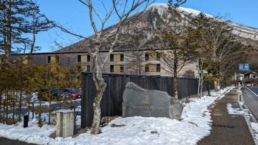 a stone sign in front of a building with snow