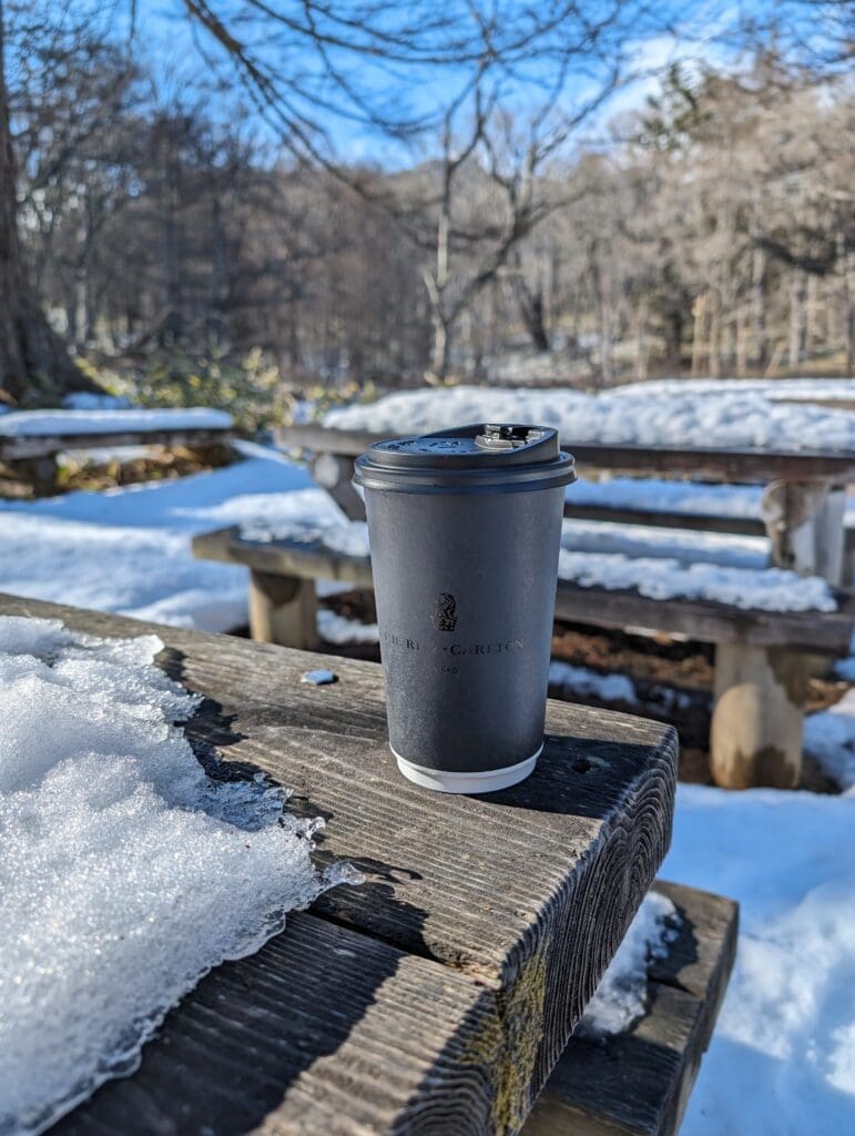 a coffee cup on a bench in the snow