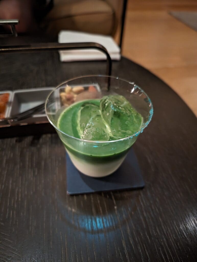 a glass of green and white drink