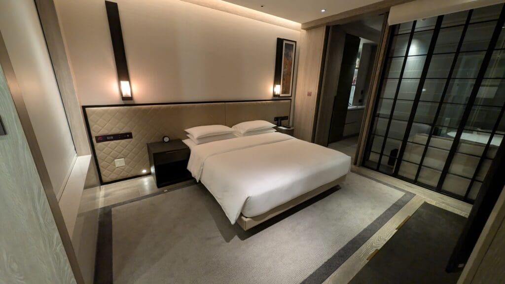 a bed with white sheets and pillows in a room