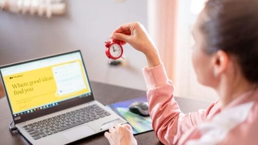 a woman holding a clock in her hand