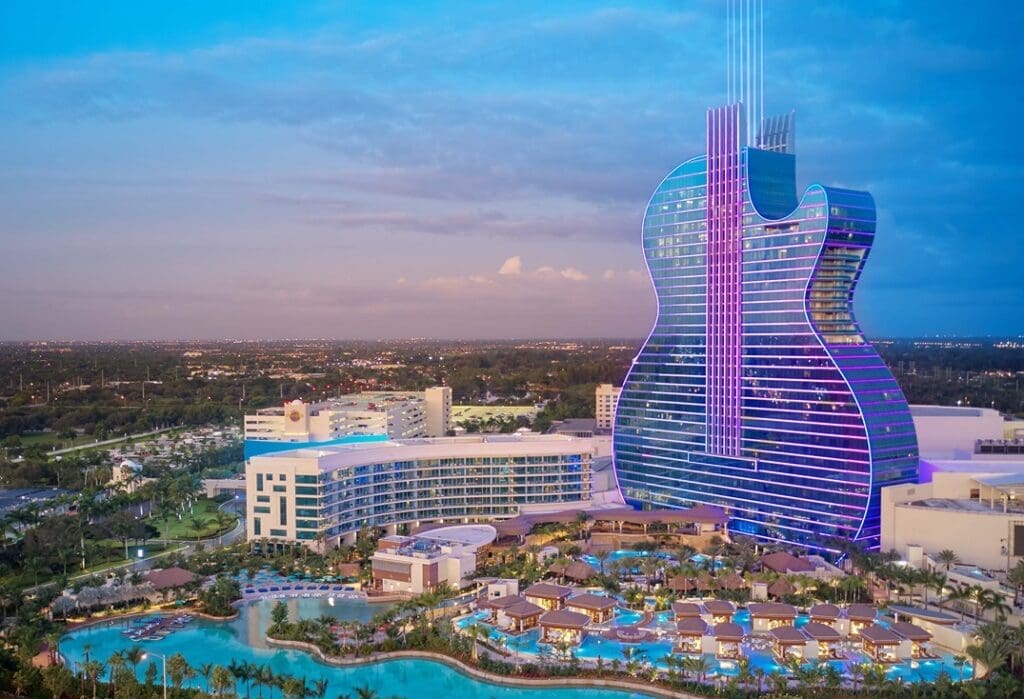 a large guitar shaped building with a pool and trees