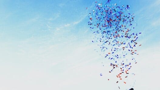 a person holding a kite with confetti in the air