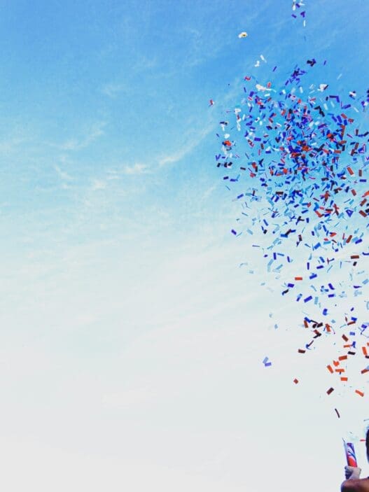 a person holding a kite with confetti in the air