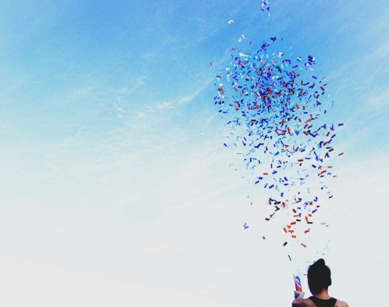 a person holding a kite with confetti in the air