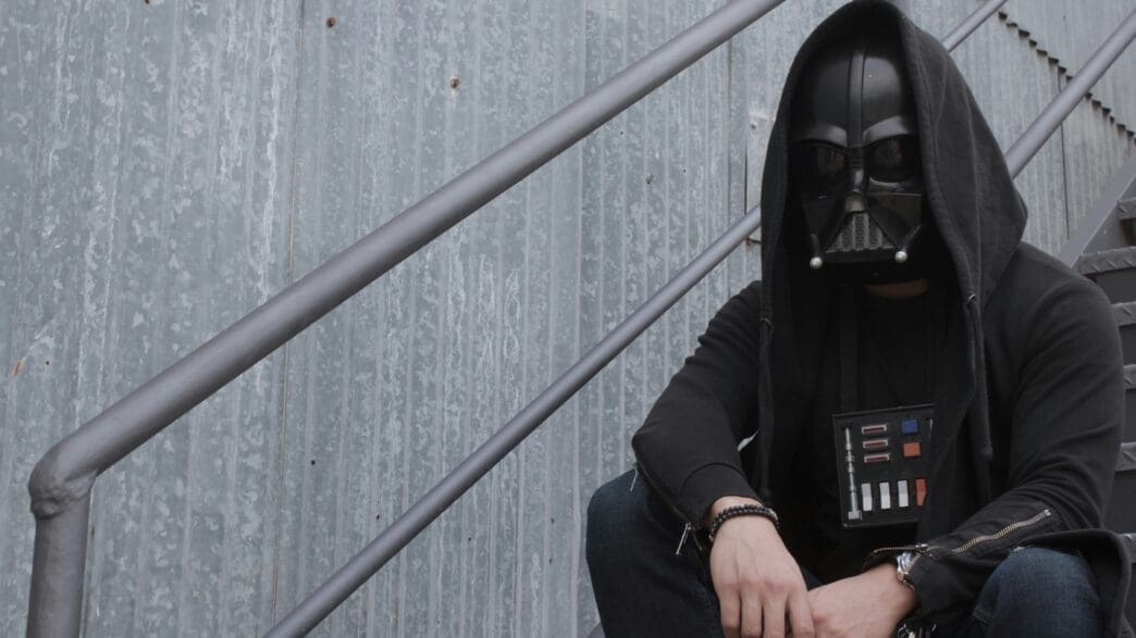 a person in a mask sitting on a staircase