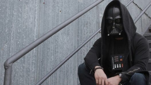 a person in a mask sitting on a staircase