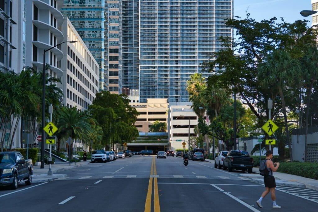 a street with cars and trees in front of a tall building