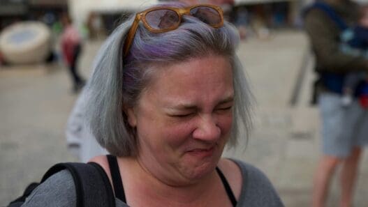 a woman with purple hair and sunglasses on her head