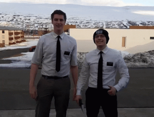 two men in ties standing in a parking lot