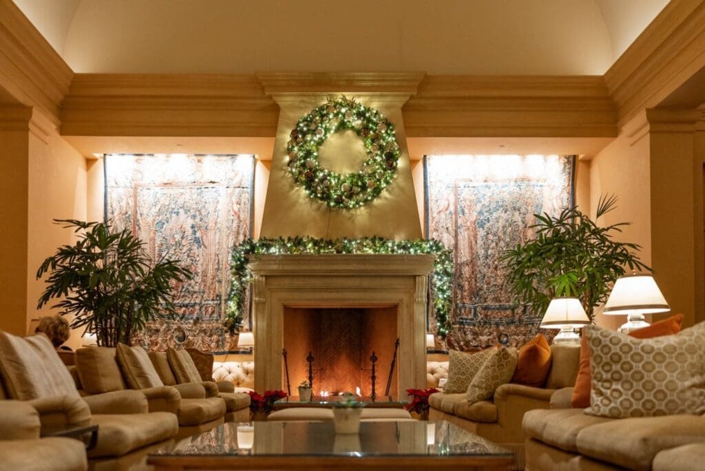 a room with a fireplace and christmas wreath