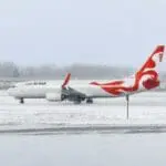 a white and red airplane on a snowy runway