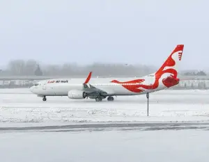 a white and red airplane on a snowy runway
