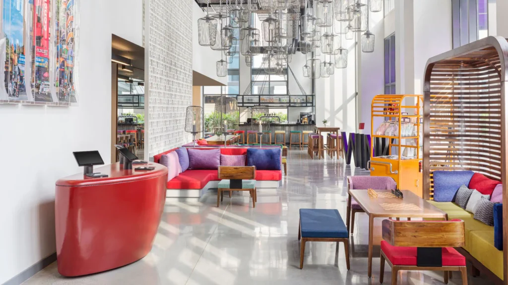 a room with a red couch and tables and chairs