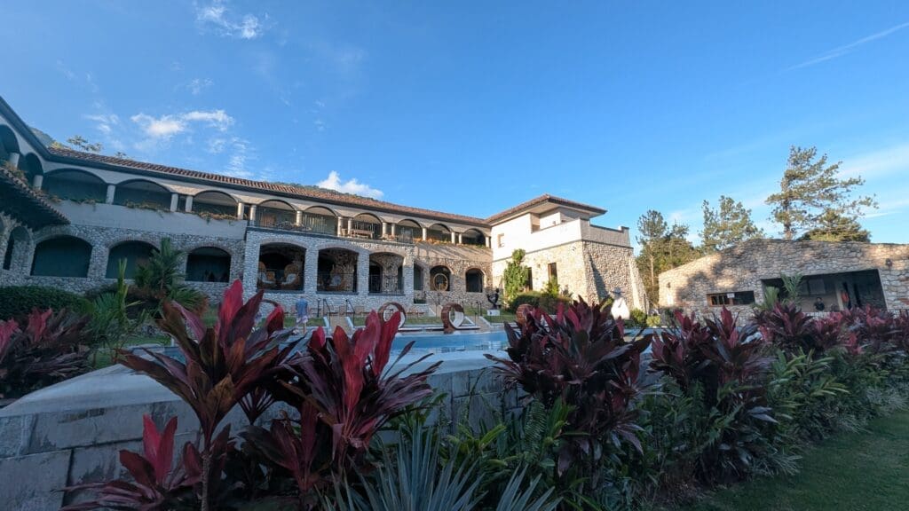 a building with a pool and plants