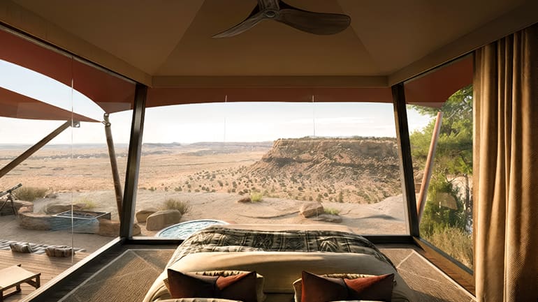 a room with a bed and a view of the desert