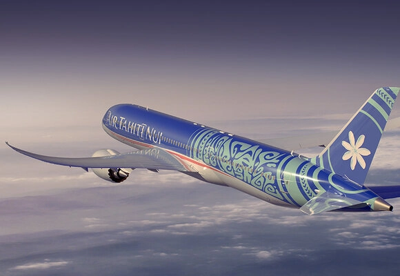 a blue and white airplane flying in the sky