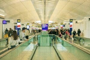 people standing on a walkway in a terminal