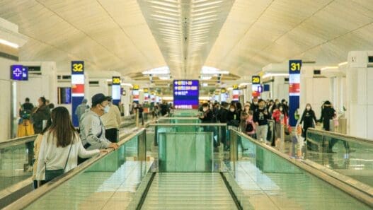 people standing on a walkway in a terminal