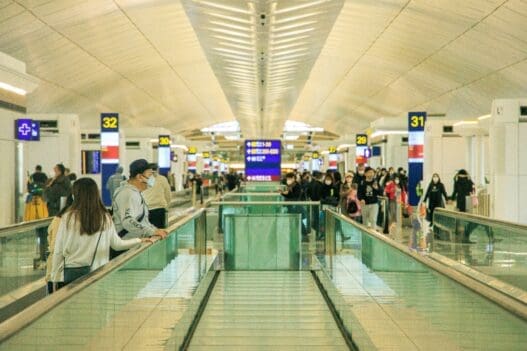 people standing on a walkway in a terminal