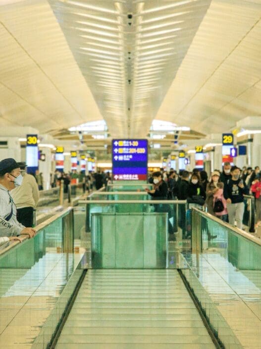 people standing on a walkway in a terminal