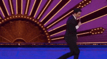 a man in a suit running on stage