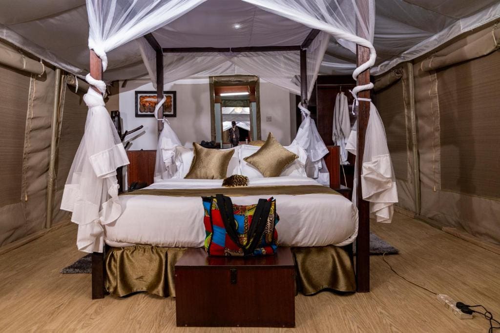 a bed with white sheets and a white canopy over it