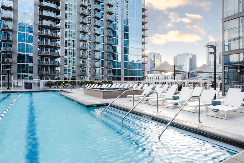 a pool with chairs and a building in the background