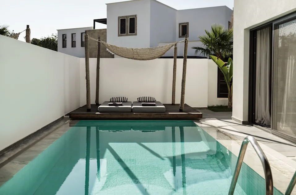 a pool with a bed and a hammock