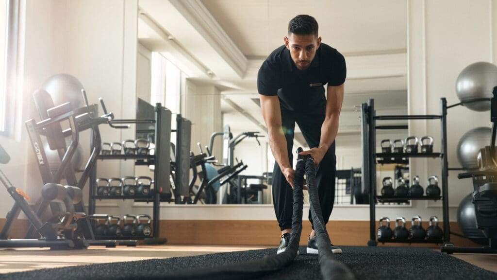 a man holding a rope in a gym